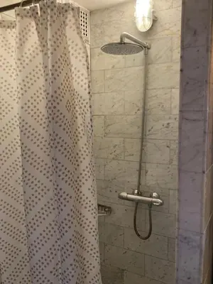 a shower with a shower curtain in a bathroom at B&B Herengracht 21 in Amsterdam