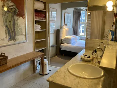 a bathroom with a sink and a bedroom with a bed at B&B Herengracht 21 in Amsterdam