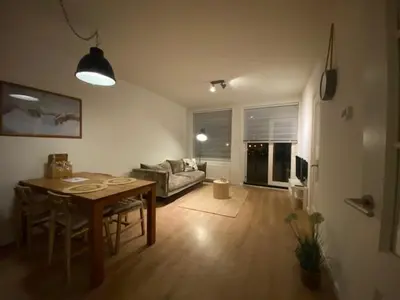 a living room with a table and a couch at NEW Appartment Zandvoort! in Zandvoort