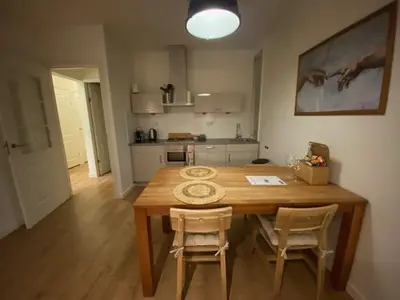 a kitchen with a wooden table and two chairs at NEW Appartment Zandvoort! in Zandvoort