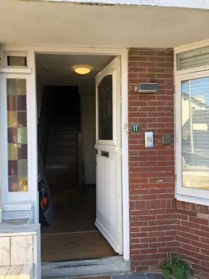 an open door of a brick house with a stair case at NEW Appartment Zandvoort! in Zandvoort