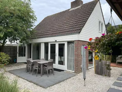 a patio with a table and chairs in front of a house at The Beach House in Noordwijkerhout