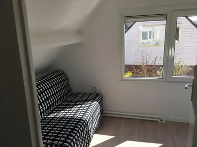 a living room with a couch and a window at The Beach House in Noordwijkerhout
