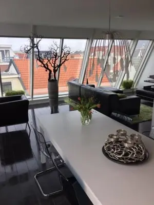 a living room with a white table and some chairs at Appartement Modern Egmond in Egmond aan Zee