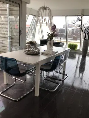 a white table with chairs and a vase on it at Appartement Modern Egmond in Egmond aan Zee