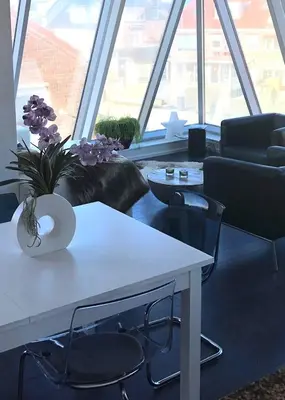 a living room with a white table and chairs at Appartement Modern Egmond in Egmond aan Zee