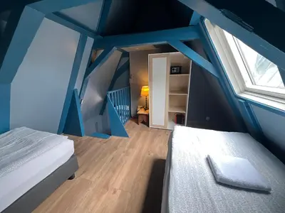 a blue room with a bed and a window at Nes B&B in Amsterdam