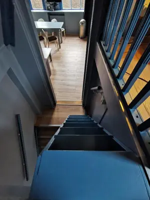 a staircase leading up to a room with a table at Nes B&B in Amsterdam
