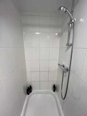 a white bathroom with a shower and a bath tub at Nes B&B in Amsterdam