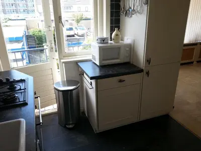 a kitchen with a microwave on a counter next to a window at Kampan in Zandvoort