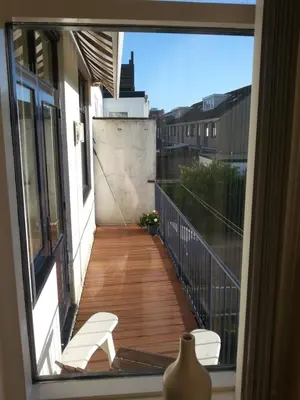 a view of a balcony with a white chair on a balcony at Kampan in Zandvoort