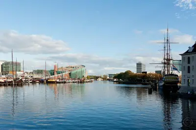 a river with boats docked in a city at Artis Plantage Apartment in Amsterdam