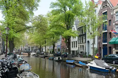 a canal in a city with boats and buildings at Artis Plantage Apartment in Amsterdam