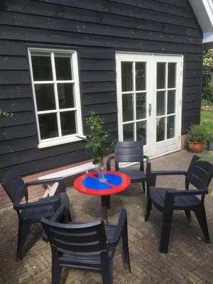 a patio with a table and chairs and a building at Gina's garden house in Amsterdam