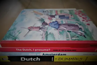 a stack of books sitting on a table at Gina's garden house in Amsterdam