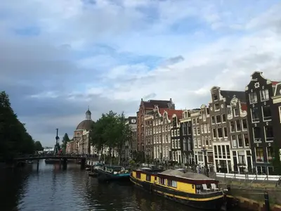 a river with buildings and boats in a city at Gina's garden house in Amsterdam