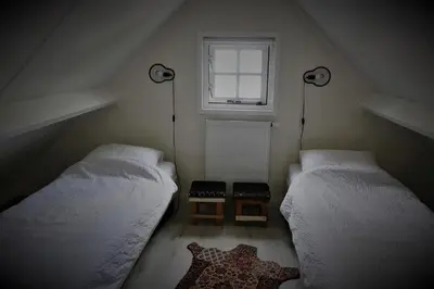 two beds in a small room with a window at Gina's garden house in Amsterdam