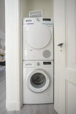 a washer and dryer in a white room at Luxury Upstairs & Downstairs Apartments in Zandvoort