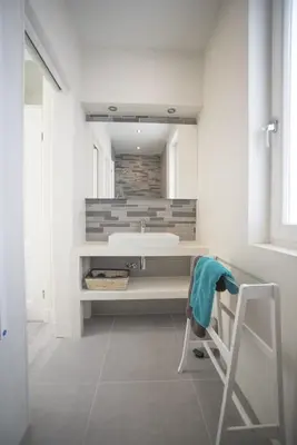 a bathroom with a sink and a chair in it at Luxury Upstairs & Downstairs Apartments in Zandvoort