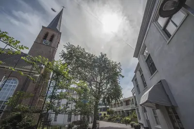 a church steeple with a clock tower on a street at Luxury Upstairs & Downstairs Apartments in Zandvoort