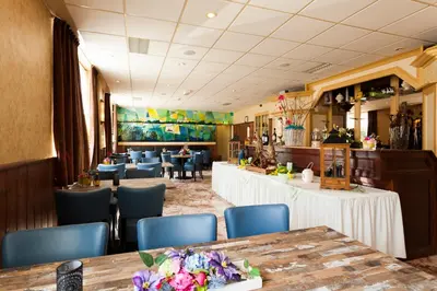 a restaurant with tables and chairs and a bar at De Vooroever in Wervershoof