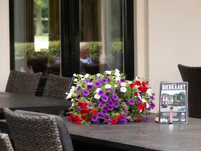 a bouquet of flowers sitting on top of a table at Hotel-Restaurant Het Rechthuis in Muiderberg