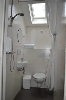 a bathroom with a toilet and a sink and a window at Hotel-Restaurant Het Rechthuis in Muiderberg
