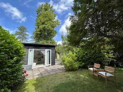 a small black shed with two chairs in a yard at Zen in Schoorl in Schoorl