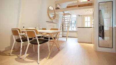 a dining room with a table and chairs and a bunk bed at Loft Leidsegracht in Amsterdam