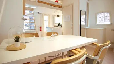 a kitchen and dining room with a white table and chairs at Loft Leidsegracht in Amsterdam