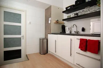 a kitchen with white cabinets and red towels at Loft Leidsegracht in Amsterdam