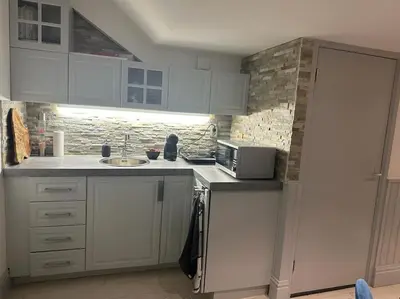 a kitchen with white cabinets and a sink at Unique Royal Basement residence in Amsterdam