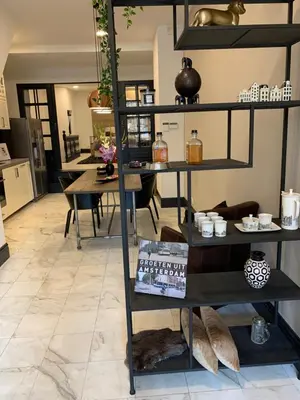 a black shelf in a room with a table at Unique Royal Basement residence in Amsterdam