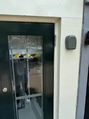 a green door with a reflection of a person in the window at Unique Royal Basement residence in Amsterdam