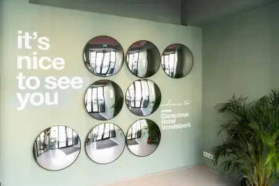 a wall with four mirrors on a wall at Conscious Hotel Vondelpark in Amsterdam