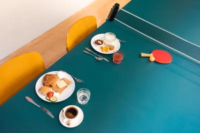a table with plates of food and a cup of coffee at Conscious Hotel Vondelpark in Amsterdam