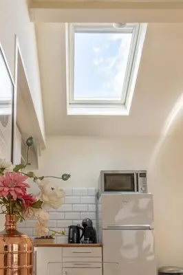 a kitchen with a window above a refrigerator at Yess in Vinkeveen
