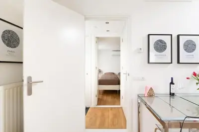 a white kitchen with a glass table and a bedroom at Yess in Vinkeveen