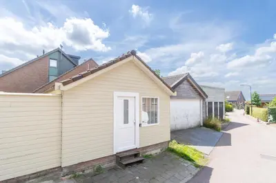 a house with a white door and a driveway at Yess in Vinkeveen