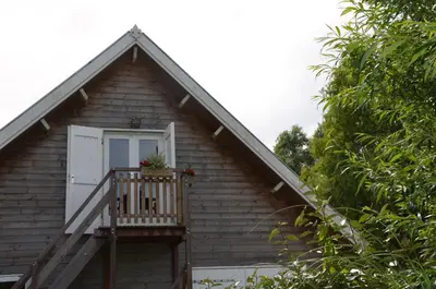 a house with a porch with a door and a balcony at B&B Nieuwe Brug in Vijfhuizen