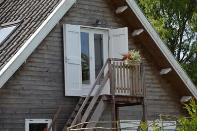 a porch of a house with a window and a basket of flowers at B&B Nieuwe Brug in Vijfhuizen
