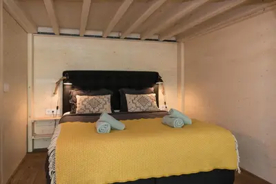 a bedroom with a large bed with two pillows at Studio Jan Steen in Amsterdam