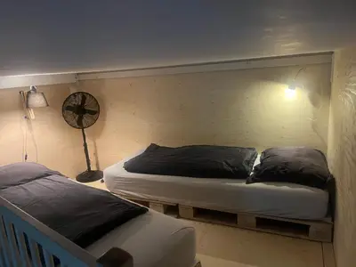 a bedroom with two beds and a clock on the wall at Studio Jan Steen in Amsterdam