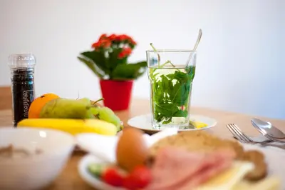 a table with a plate of food and a glass of juice at i hotel in Amsterdam