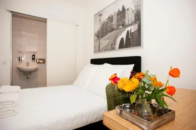 a bedroom with a bed and a table with flowers at i hotel in Amsterdam
