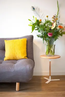 a vase of flowers on a table next to a couch at i hotel in Amsterdam