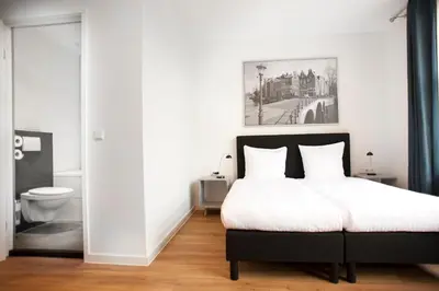 a bedroom with a bed and a bathroom with a toilet at i hotel in Amsterdam