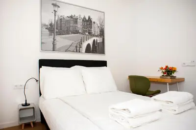a bedroom with a white bed with a picture on the wall at i hotel in Amsterdam