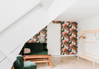 a living room with a green couch and a floral wall at Bergen1928 in Bergen
