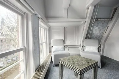 a room with two chairs and a table and a window at 't Hotel in Amsterdam